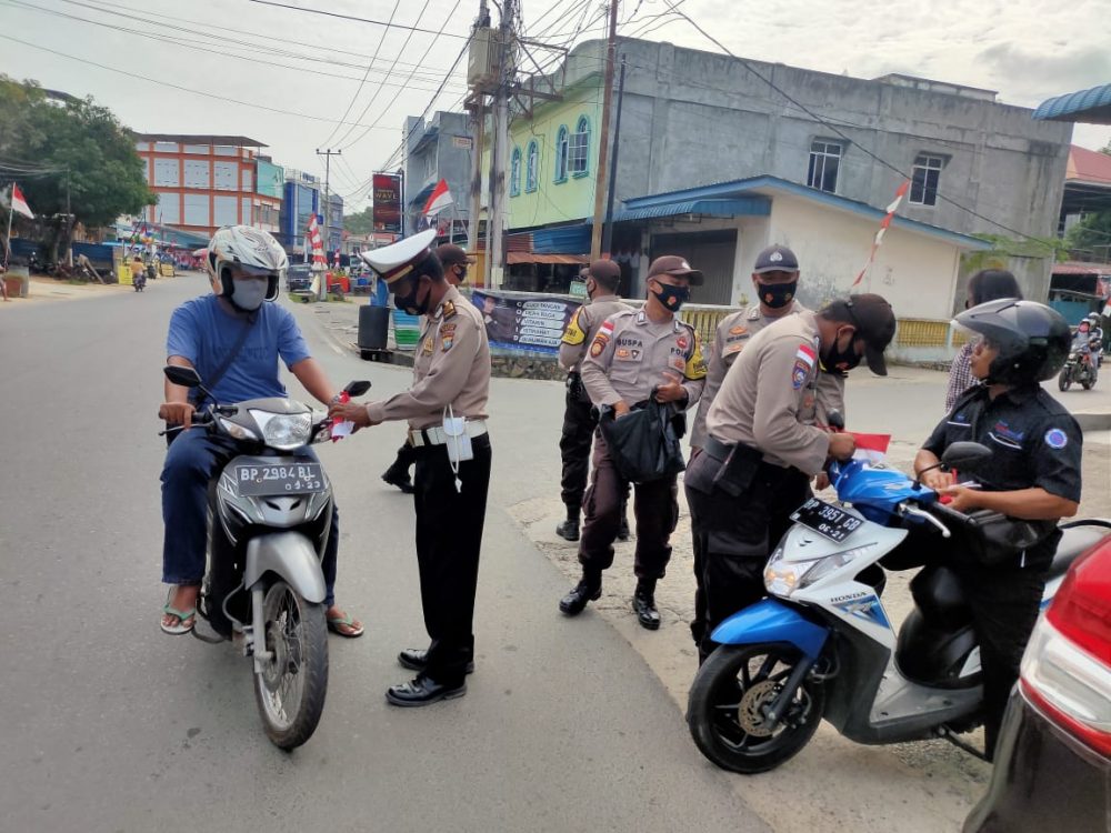 Sambut HUT RI ke-75, Polsek Bintan Utara Pasangkan Bendera Merah Putih Kepada Pengendara