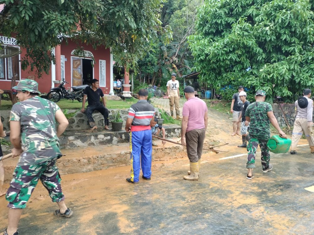 Personil Koramil 06/Serasan Bersama Warga Bersihkan Bahan Material Longsor Di Jalan Umum