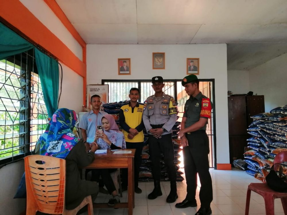 Babinsa Pratu Jhon Sirait Bersama Bhabinkamtibmas Dampingi Penyaluran Bantuan Beras Bagi Warga Kurang Mampu