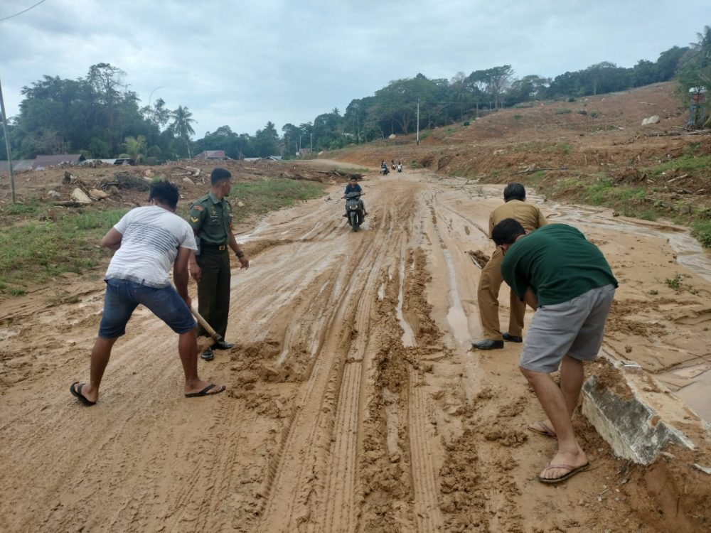 Sinergitas Babinsa Sertu Hendry Bersama Warga Bersihkan Badan Jalan dari Material Tanah